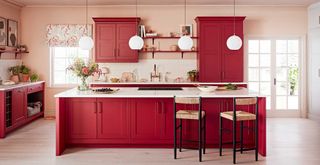 Kitchen with red cabinets and light pink walls to show bold new kitchen trends 2023