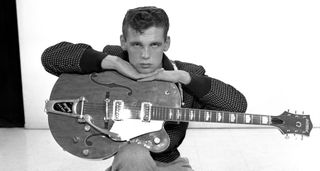 A black-and-white portrait of Duane Eddy resting on his Gretsch from 1958