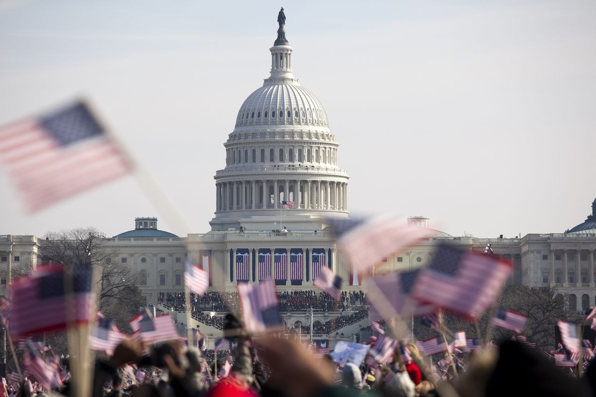 Photo of the U.S. Capitol behind of a crowd waving American flags at President Obama&#039;s inauguration on Jan. 20, 2009. 