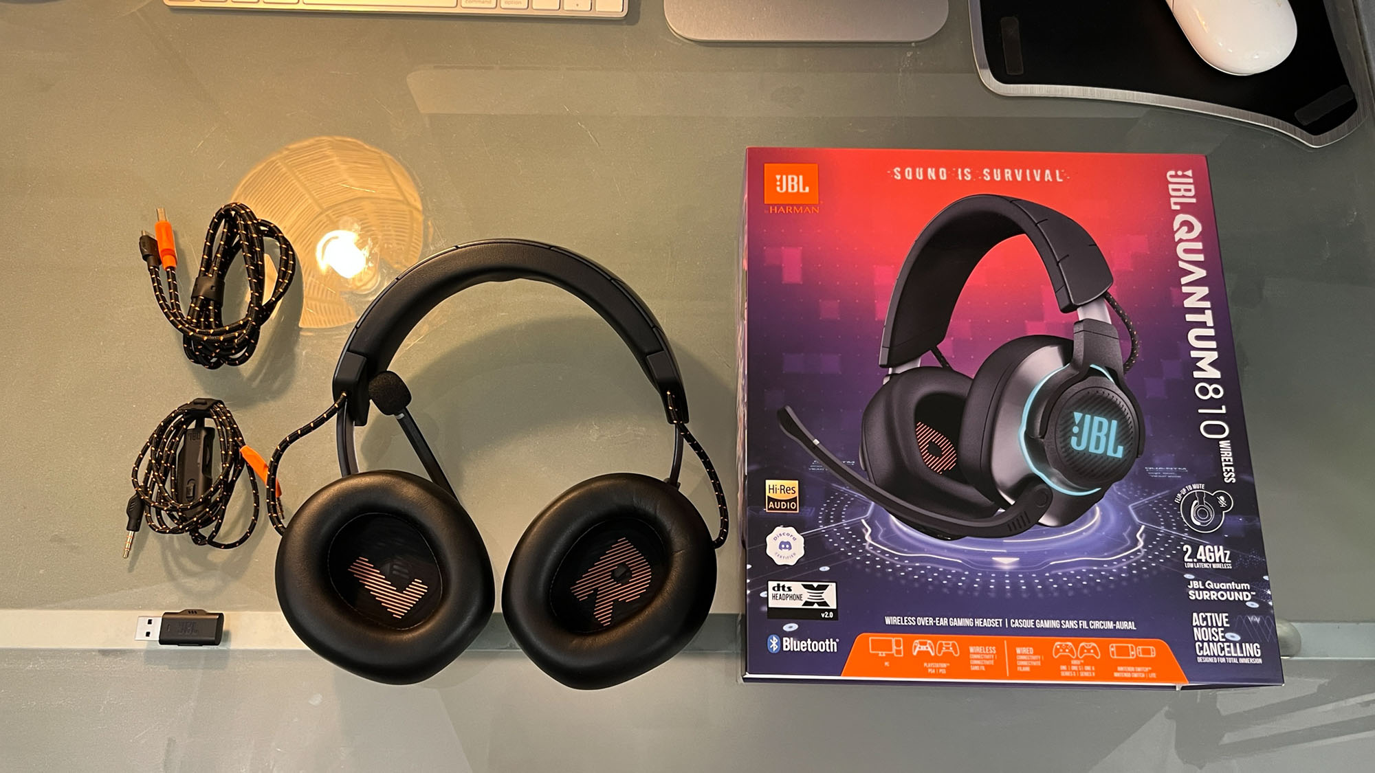 A JBL Quantum 810 Wireless gaming headset on a desk