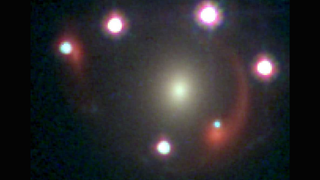 An arc of four purple lights over an elongated yellow orb next to a red swirl with a fifth purple orb at the bottom of the image