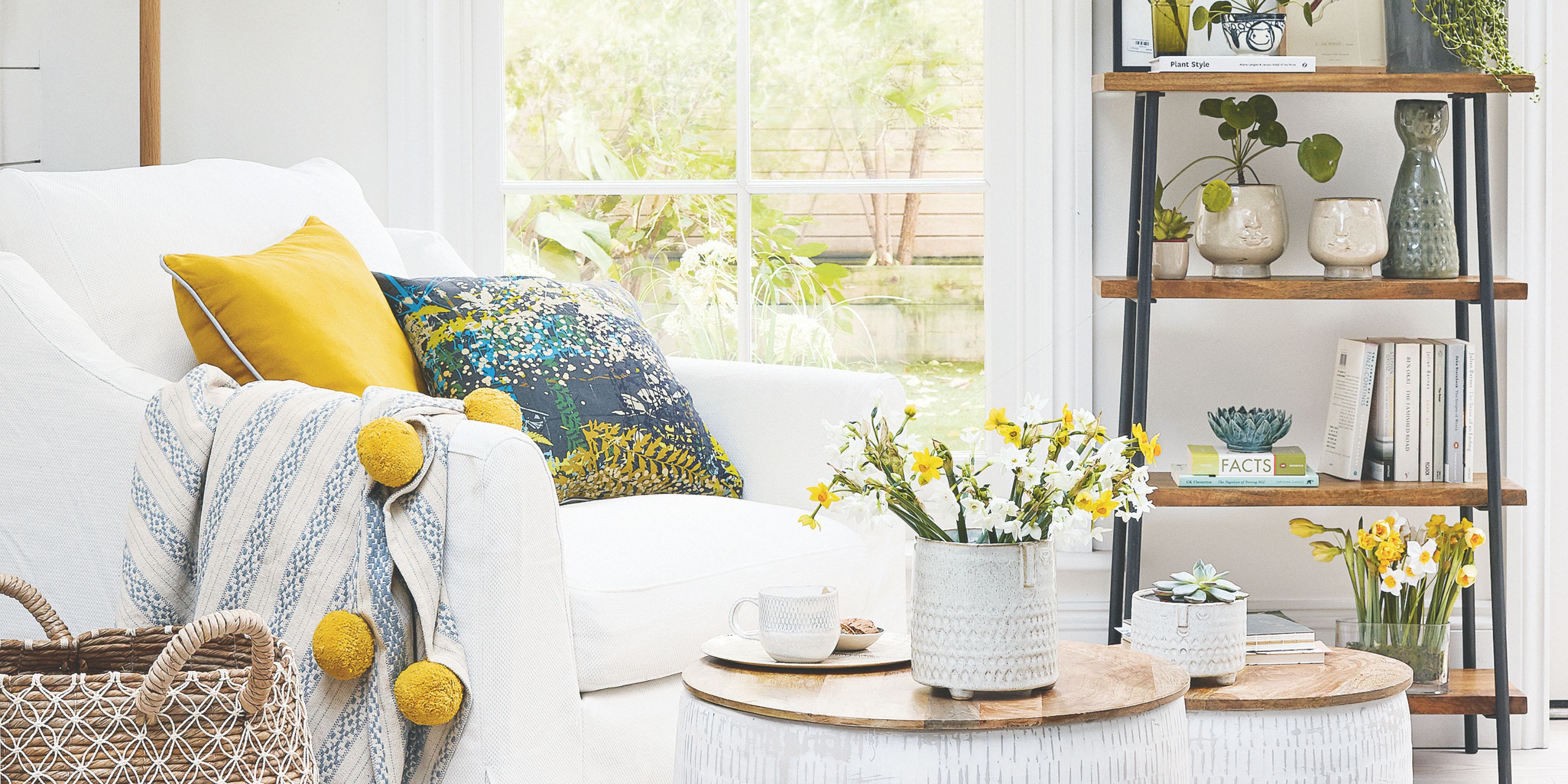 A fresh living room space with white and wooden interiors, yellow accents, and fresh flowers