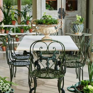 balcony with plant in pots and dining table with chairs