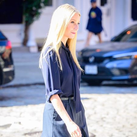 Gwyneth Paltrow wears a pleated skirt and black loafers.