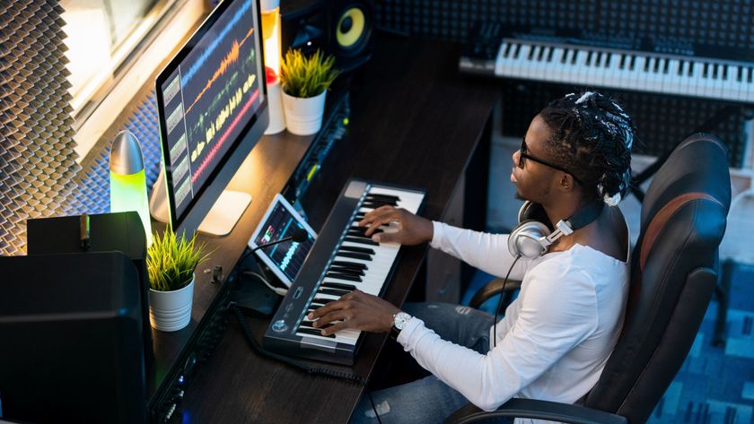 A person composing with a synth at a PC