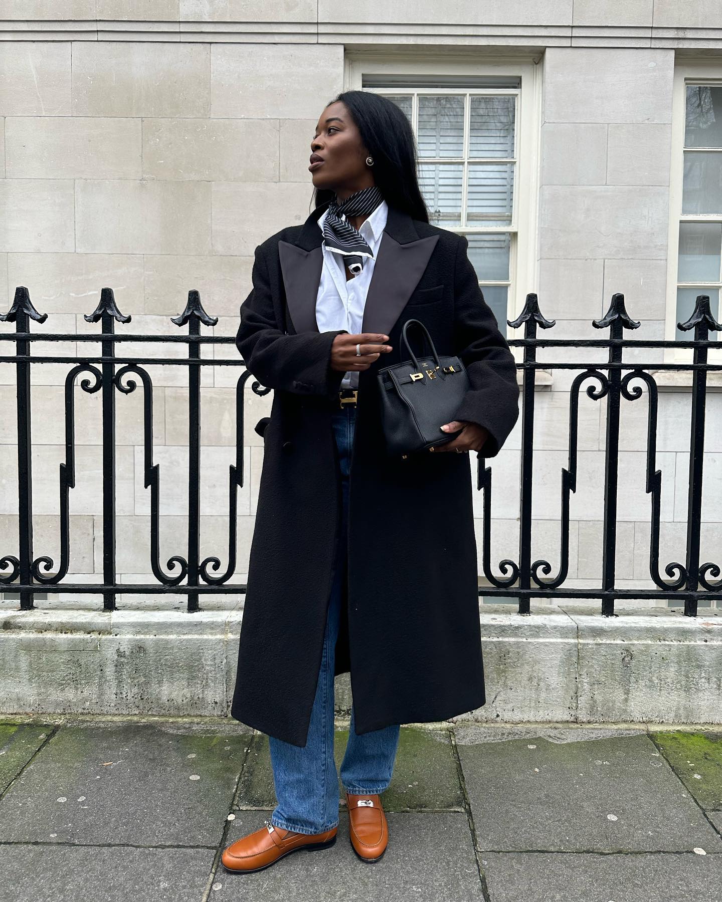 @nlmarilyn wears blue bootcut jeans with tan loafers.