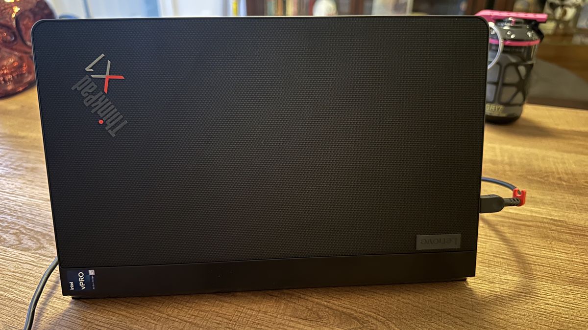 The Lenovo ThinkPad X1 Fold 16 Gen 1 seen from the back on a wood desk