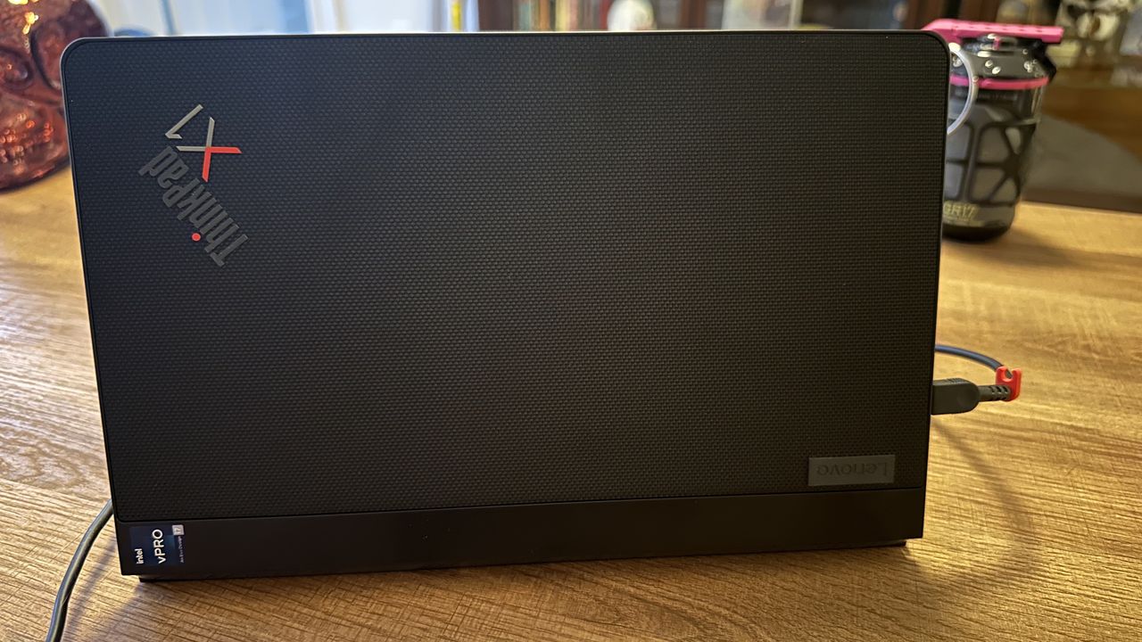 The Lenovo ThinkPad X1 Fold 16 Gen 1 seen from the back on a wood desk