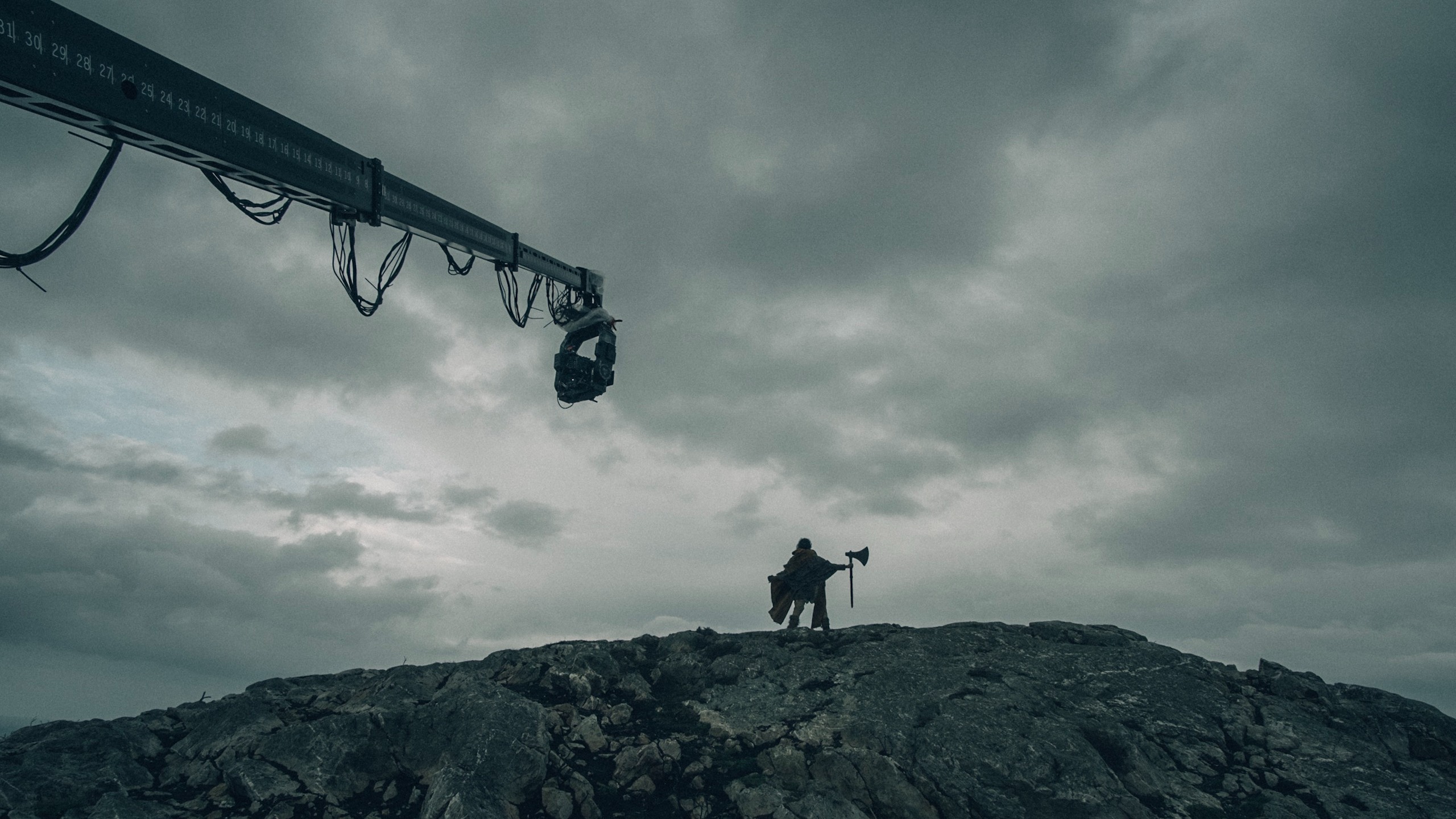 A crane camera used being used on the set of The Green Knight