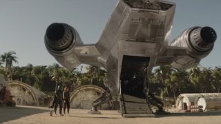 an armored sci-fi warrior in silver and a woman stood behind a spaceship.