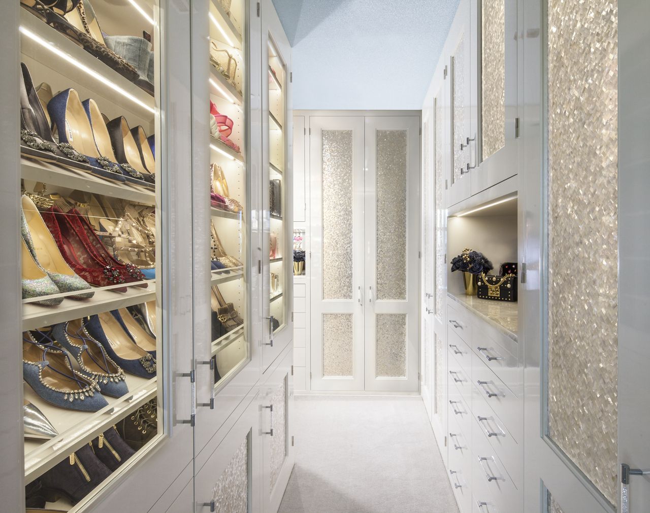 luxury white closet with glass fronted shoe storage