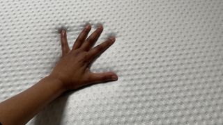 Emma Mattress with tester's hand resting on it