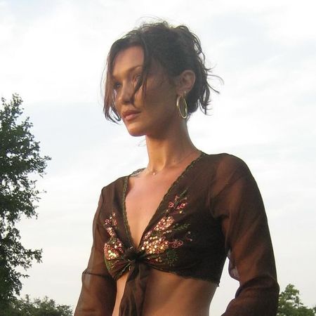 Bella Hadid wearing a vintage flowy brown top, suede midi skirt, and cowgirl boots to promote Orebella in new Instagram post May 2024