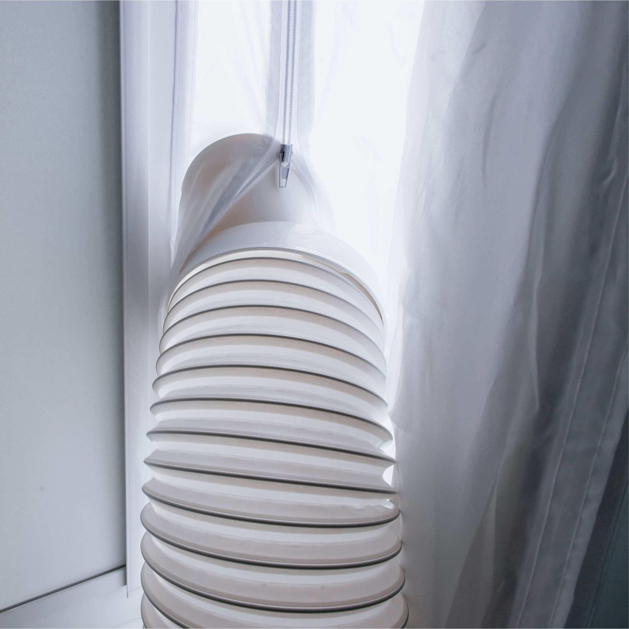 Portable air conditioner exhaust hose vented through fabric window kit