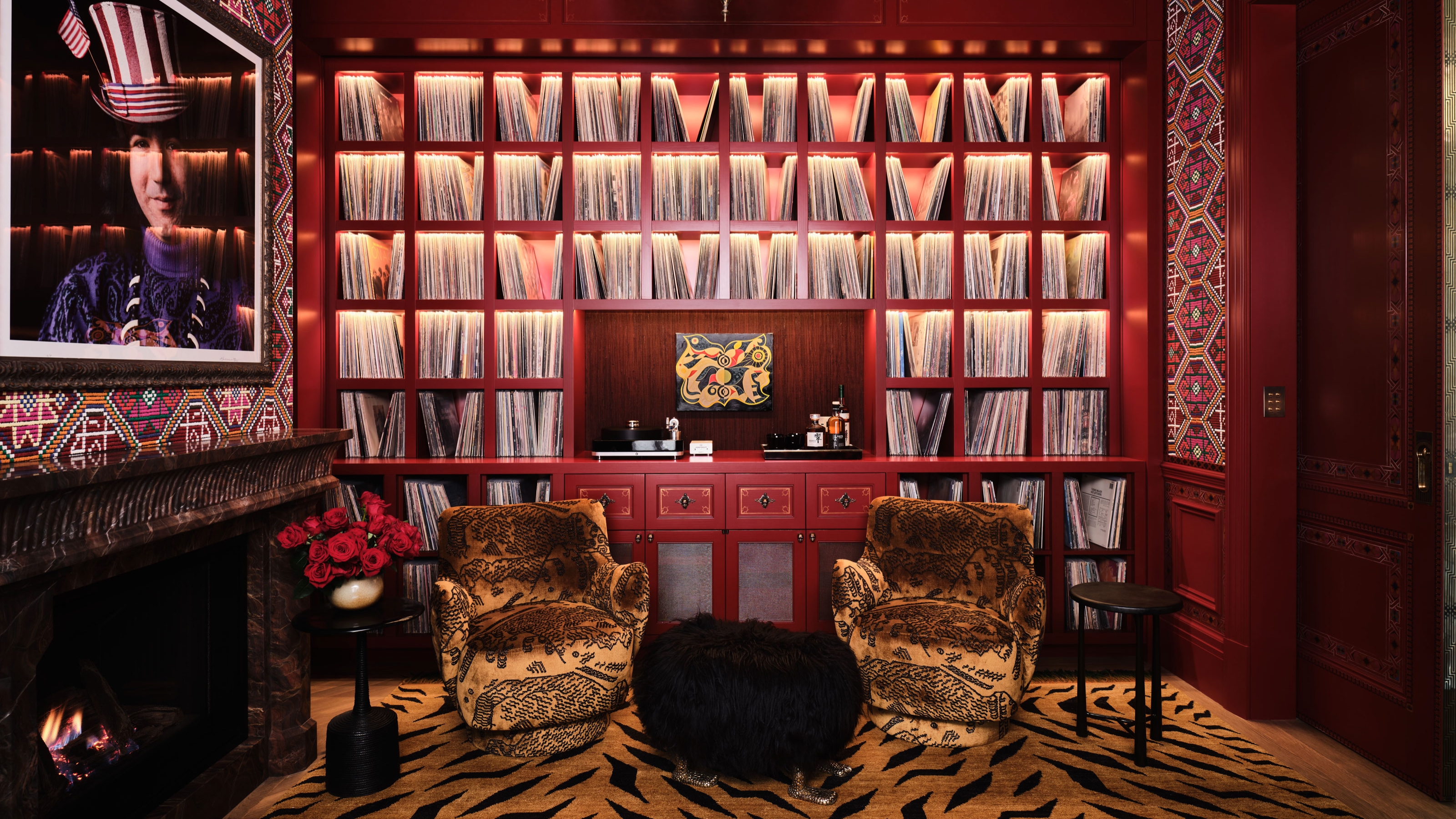 a red maximalist library with an animal print rug and tiger print chairs