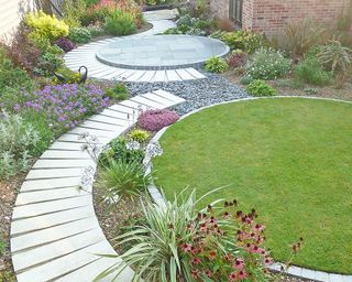 paved path linking a circular lawn and matching circular patio