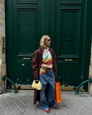 Influencer wears a burgundy coat.