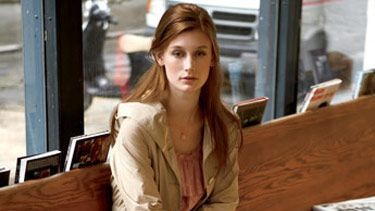 woman sitting on bench with books