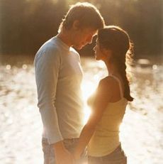 couple holding hands by a lake