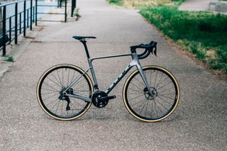 A Vitus Venon Evo RD road bike stands on a paved canal path 