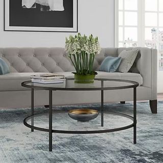 A round glass coffee table with two tiers and black edges