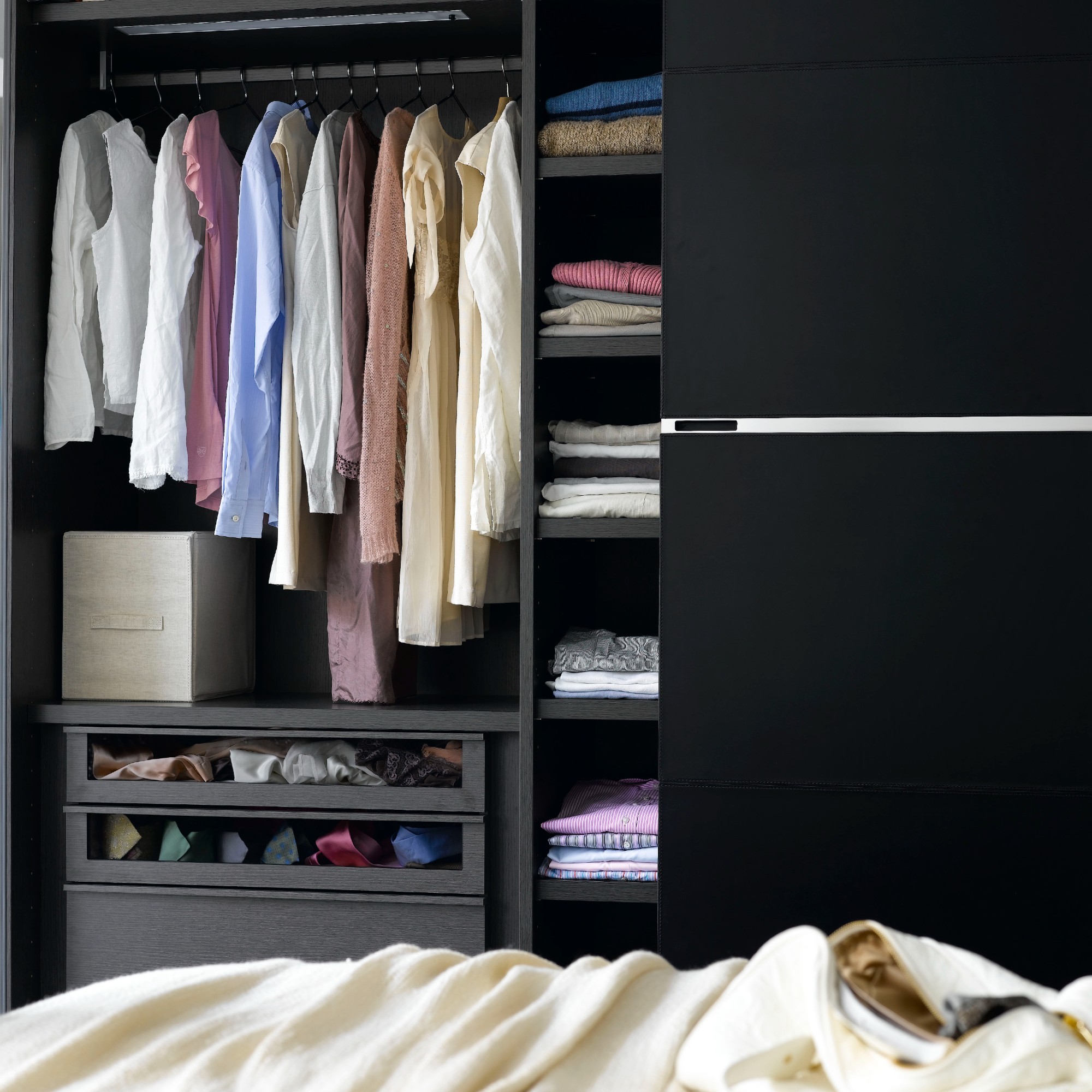 A bedroom with black wardrobes with sliding doors