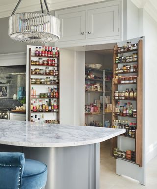 Pantry door ideas with double doors with shelving on the inside of them, an island and oven area