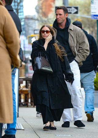 Ashley Olsen in an all-black outfit and The Row Lady bag, walks with Nicolas Turko in New York City