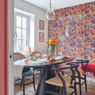 Dining room with pink patterned wallpaper, dining table and chairs