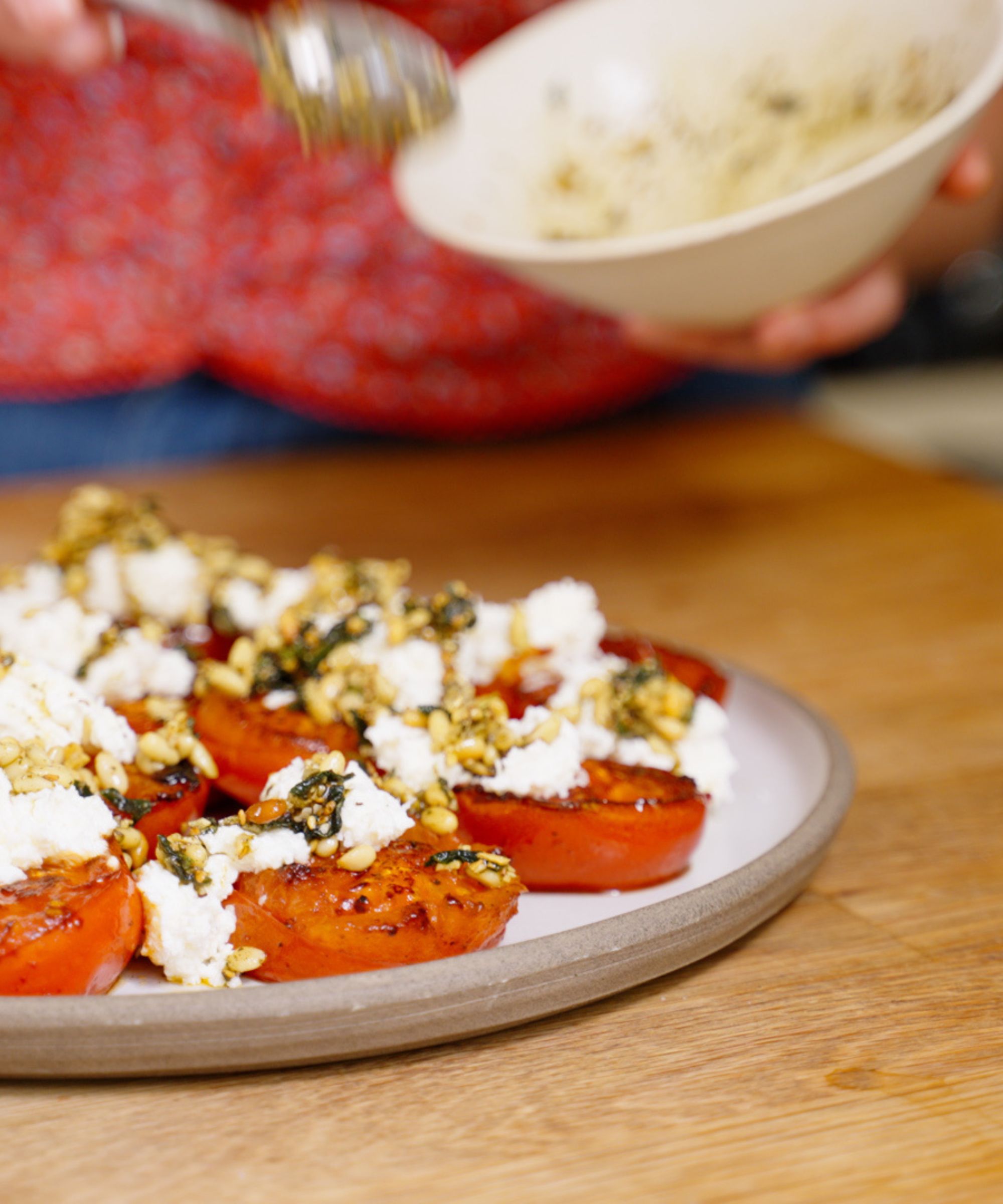 Plate of tomatoes with halloumi and pine nuts