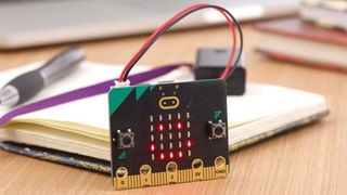 The new BBC Micro:bit displayed in front of a notebook and pen