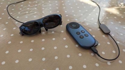 The Rokid Max AR glasses connected to the Rokid Station via a cable while they sit on a polka dot covered table