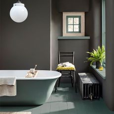 bathroom with grey shade wall and grey bathtub and wooden floor and chair and towel