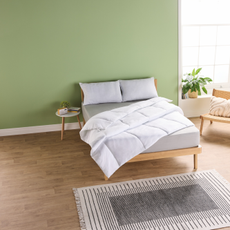 Aldi cooling bedding on a double bed in a bedroom with green walls.