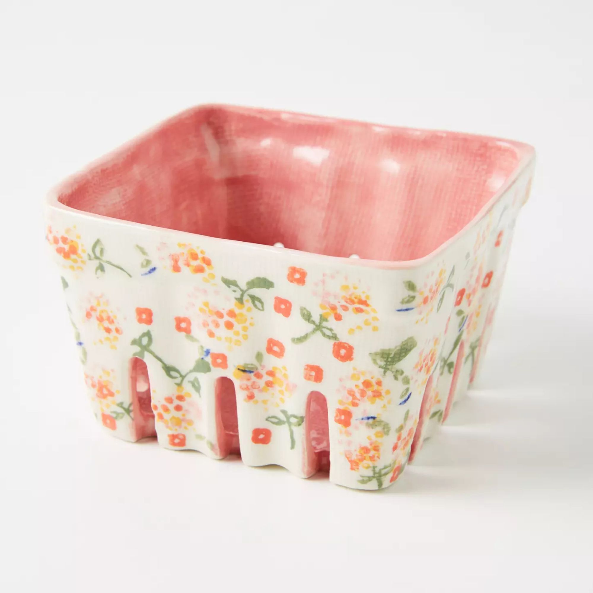 Ceramic berry basket with pale pink interior and white exterior illustrated with pink and yellow flowers