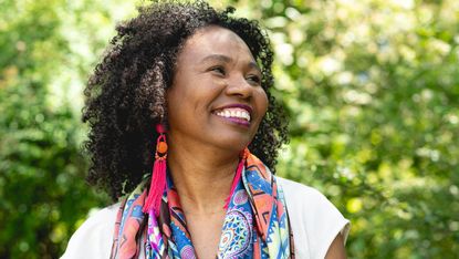 Portrait of a laughing, dark-skinned woman with curly hair and colourful scarf, Germany - stock photo