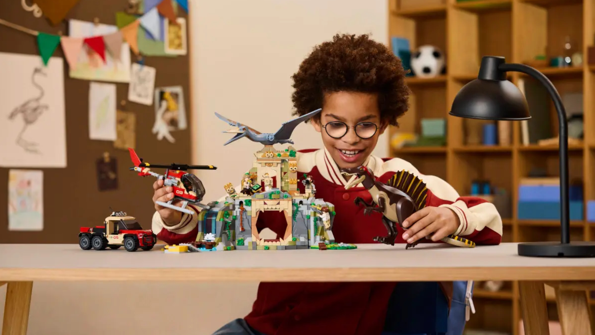 A child plays with the Spinosaurus & Quetzalcoatus kit on a table
