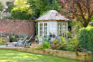 summer house ideas: Malvern Garden Buildings blue summer house in corner of plot