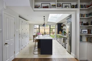 white kitchen diner with dark statement island and pendant lights