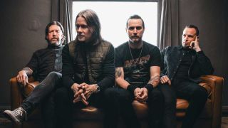 Alter Bridge sitting in front of a window