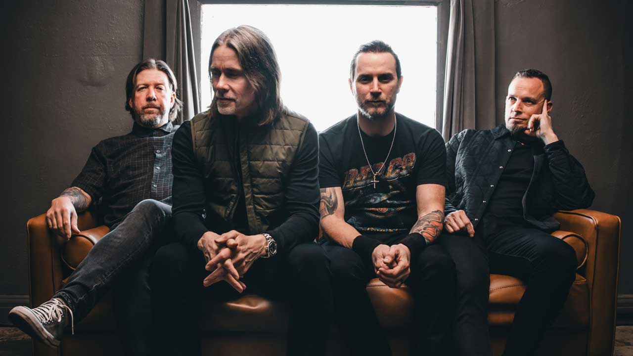 Alter Bridge sitting in front of a window