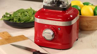 KitchenAid K400 in red next to a bowl of spinach