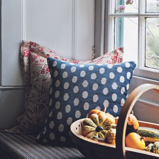 Window seat with basket of fruit and two cushions