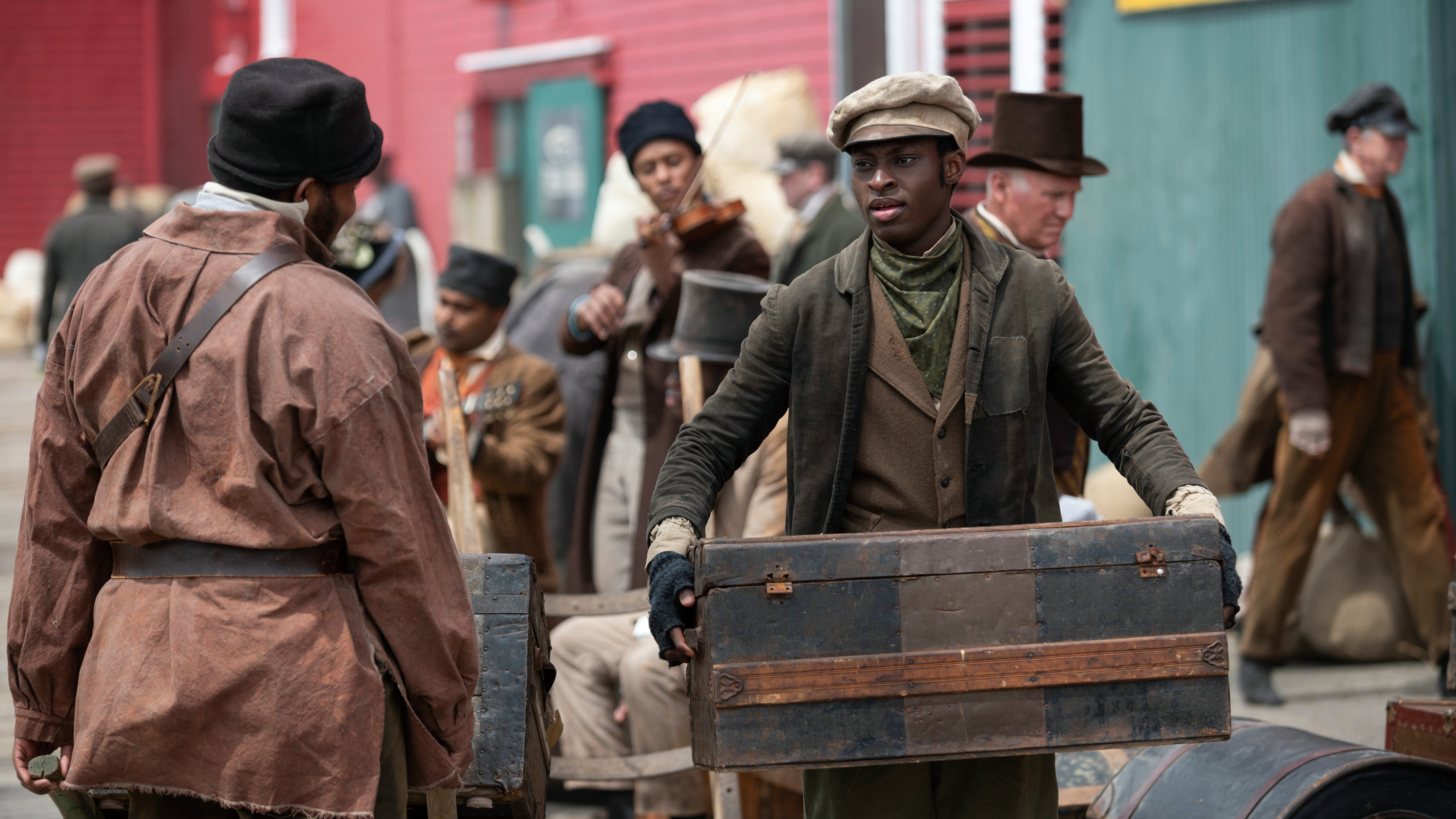 Ernest Kingsley Jr. carries a trunk in a scene from "Washington Black"