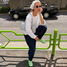 Influencer Tori Van Breugel wearing neon green trainers, white long-sleeve t-shirt, jeans and headscarf. 