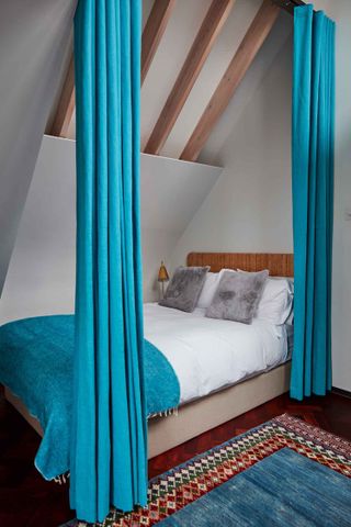 Guest bedroom with blue curtains to divide the space