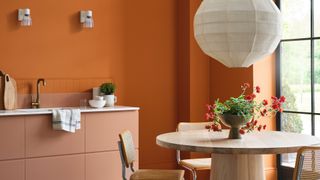peach kitchen with orange walls dining table and flowers