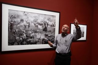 50 best photographers ever: Sebastiao Salgado in front of one of his pictures from Genesis