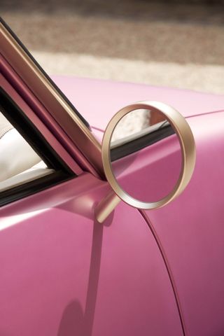 close-up of wing mirror on pink car