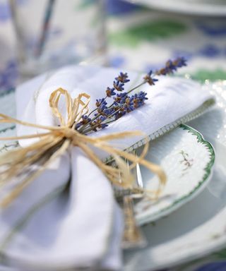 A close-up shot of a linen napkin tied with lavender and raffia